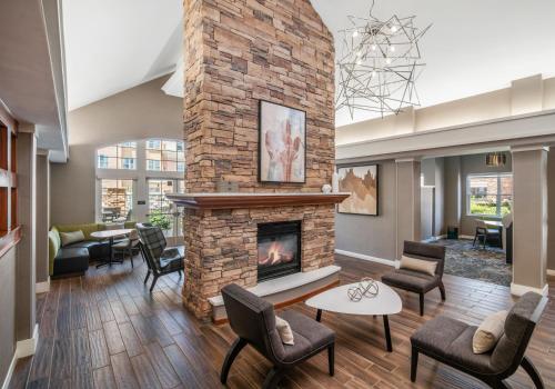 a living room with a brick fireplace and chairs at Residence Inn Phoenix Glendale Sports & Entertainment District in Glendale