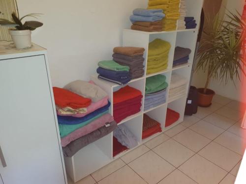 ein Zimmer mit einem Regal mit bunten Handtüchern in der Unterkunft Messeblick 1,2 km, Relax- App "Biene und Hummel" romantisch, Doppelzimmer gut & günstig in Hannover