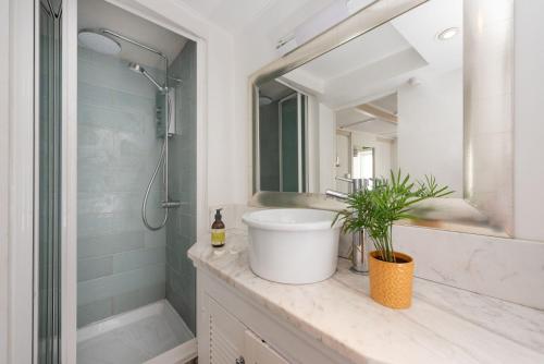 a bathroom with a sink and a shower and a mirror at Mariners Cottage, St Ives in St Ives