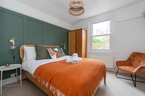 a bedroom with an orange bed and a chair at Chic Townhouse in the heart of Historical Exeter 5mins to Centre in Exeter