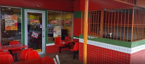 a fast food restaurant with red chairs and tables at The Layover - 6 mins from the airport, Fully equipped for short and long stays in Kelly Village