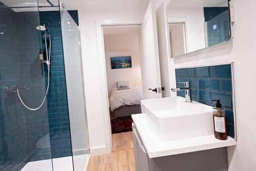 uma casa de banho com um lavatório branco e um chuveiro em The Courtyard Apartment with parking em Ilfracombe