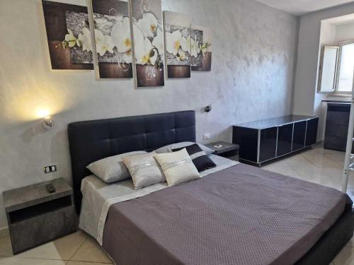 a bedroom with a large bed with paintings on the wall at Casa Vancanza Happy Holidays in Pompeii in Pompei