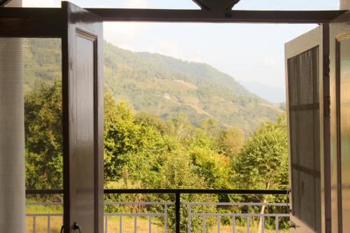 an open window with a view of a mountain at The Bunksters Bir in Bīr