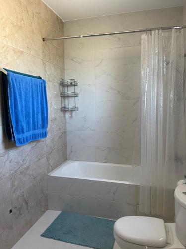 W łazience znajduje się wanna, toaleta i niebieski ręcznik. w obiekcie VILLA CORAL VIEW w mieście Peja