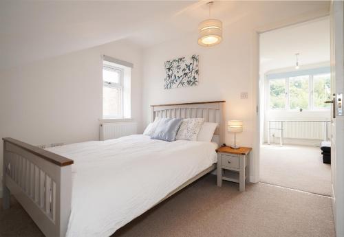 a white bedroom with a large bed and windows at Luxury Home with Hot Tub BBQ Pool Table in Chesterfield