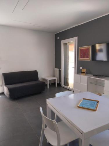 a living room with a white table and a black couch at Sirene452 - apartment - in Torvaianica