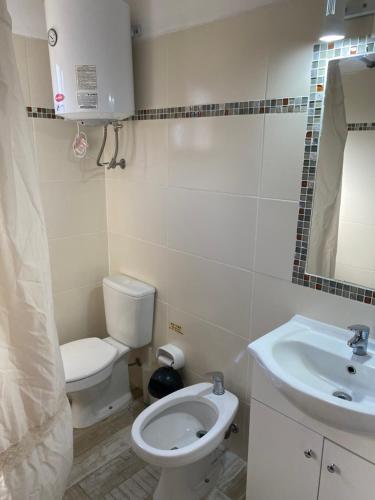 a small bathroom with a toilet and a sink at Los Nidos in Piriápolis