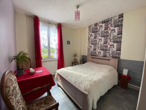 1 dormitorio con 1 cama, mesa roja y silla en Relais mm bessard, en Saint-Pierre-de-Varengeville