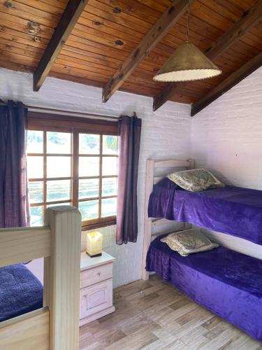 2 letti a castello in una camera con soffitto in legno di Los Nidos a Piriápolis