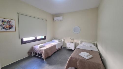 a hospital room with two beds and a window at Central Two Bedroom Apartment, No 101, by IMH Travel & Tours in Paphos