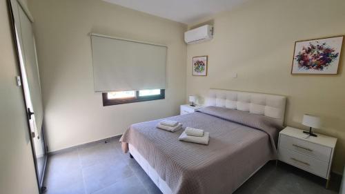 a bedroom with a bed with two towels on it at Central Two Bedroom Apartment, No 101, by IMH Travel & Tours in Paphos