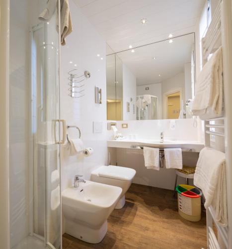a bathroom with a sink and a toilet and a mirror at Best Western Hotel Nazionale in Sanremo