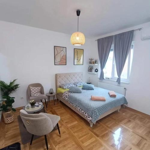 a bedroom with a bed and a chair at Stan na dan Zvornik in Zvornik