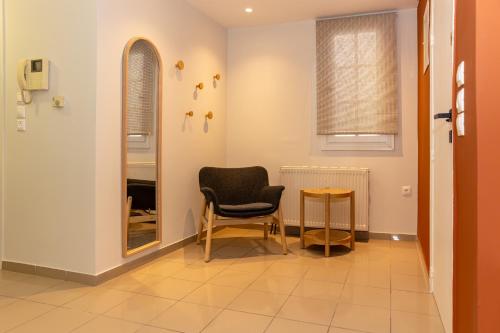 a hallway with a chair and a table at Lycabettus Athens in Athens