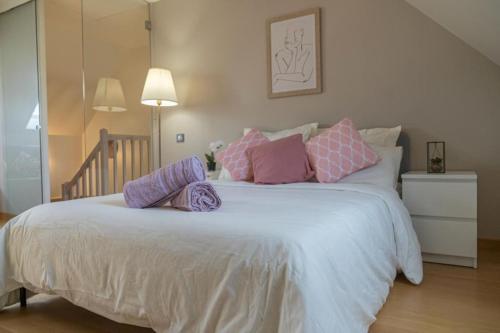 Elle comprend un grand lit avec des oreillers roses et violets. dans l'établissement Belle Demeure en bord de Seine, à Villeneuve-la-Garenne
