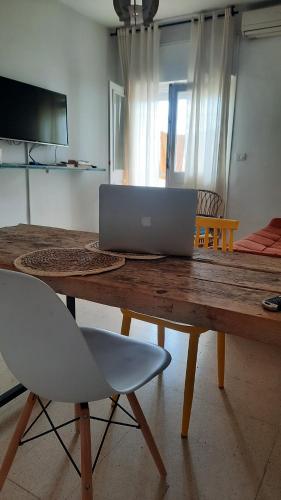 a wooden table with a laptop on top of it at aychik homestay in Ariana