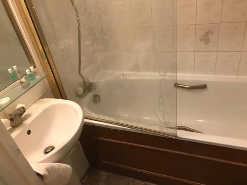 a bathroom with a toilet and a tub and a sink at Holidayaparthotel 4 in London