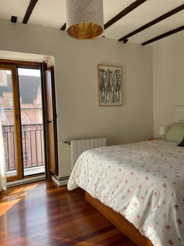 een slaapkamer met een bed en een groot raam bij Casuca Los Cencerros in Santander