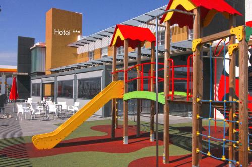 a playground with a slide in front of a building at HOTEL MAUROS EL PUIG in El Puig