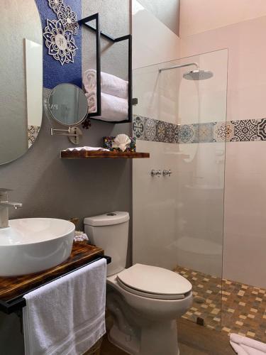 y baño con aseo, lavabo y ducha. en PASEO REAL HOTEL BOUTIQUE, en Uruapan del Progreso