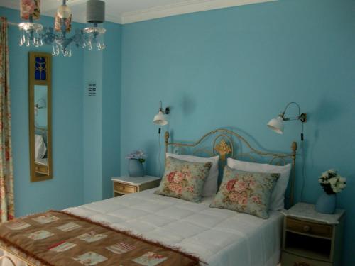 Schlafzimmer mit blauen Wänden und einem Bett mit Kissen in der Unterkunft Villa Spozendus in Esposende