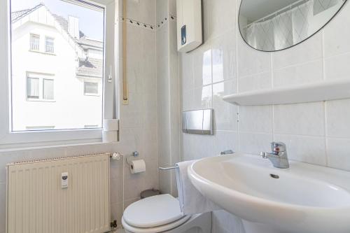 W łazience znajduje się umywalka, toaleta i lustro. w obiekcie GOLDVILLA - Wesseling w mieście Wesseling