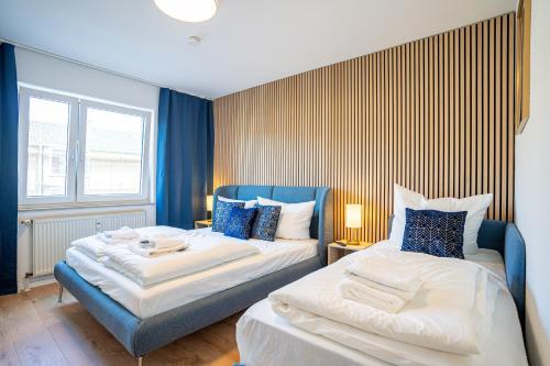 dwa łóżka w pokoju niebiesko-białym w obiekcie GOLDVILLA - Wesseling w mieście Wesseling