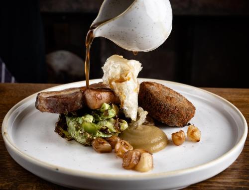 a white plate with a sandwich on a table at George and Dragon Clifton in Penrith