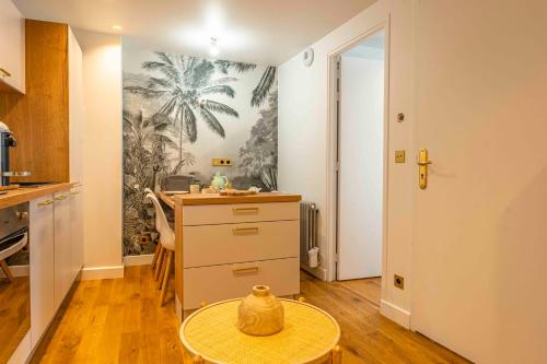 a kitchen with a desk and a table with a vase at Orion in Trouville-sur-Mer