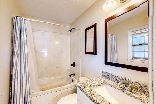 ein Badezimmer mit einem Waschbecken, einer Badewanne und einem Spiegel in der Unterkunft Towering Pines in Southaven