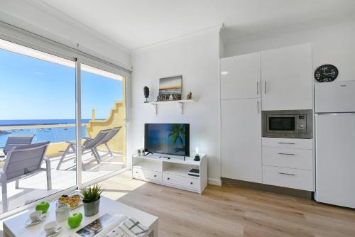 un soggiorno bianco con vista sull'oceano di Maranuelas Beachfront 305 FP by VillaGranCanaria a Arguineguín