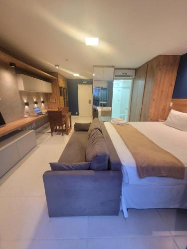 een grote slaapkamer met een groot bed en een bank bij Vision Executive Premium Esplanada in Brasilia