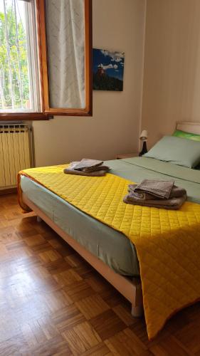 sypialnia z 2 łóżkami z żółtą pościelą i oknem w obiekcie Apartament Cedro del Libano w mieście Marano
