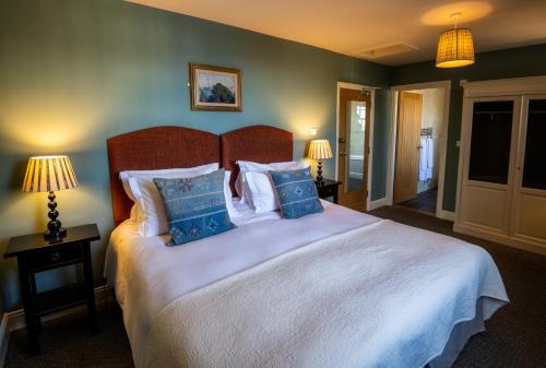 a bedroom with a large white bed with blue pillows at George and Dragon Clifton in Penrith