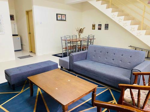 a living room with a blue couch and a table at CASA ADELIA GUESTHOUSE 2 DESA SOLEHAH in Cukai