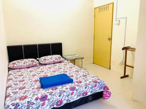 Un dormitorio con una cama con una caja azul. en CASA ADELIA GUESTHOUSE 2 DESA SOLEHAH en Cukai