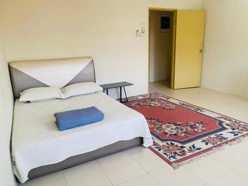 1 dormitorio con 1 cama grande y 1 alfombra en CASA ADELIA GUESTHOUSE 2 DESA SOLEHAH en Cukai