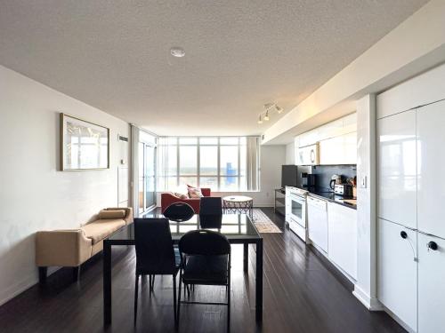 a kitchen and living room with a table and chairs at Downtown Condo - Free Parking/Self Check-in in Toronto