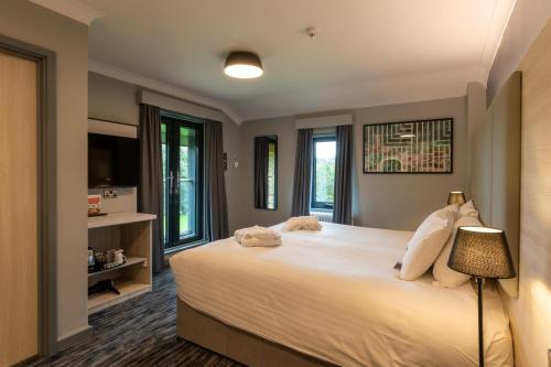 a bedroom with a large white bed and windows at Warwick Conferences - Scarman in Coventry