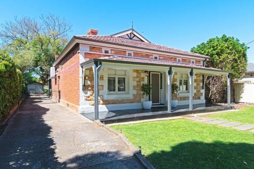a small brick house with a grass yard at Charming 3-Bedroom Sandstone Haven with free wine in Norwood