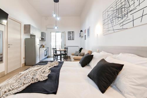 a large white bed with black pillows in a room at Il Cortile dei Cantori in Lecce