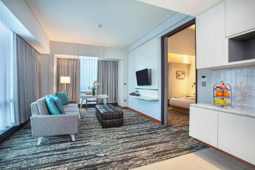 a hotel room with a couch and a television at THE 1O1 Jakarta Airport CBC in Tangerang