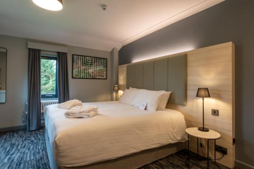 a bedroom with a large white bed and a window at Warwick Conferences - Scarman in Coventry