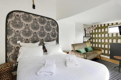 una camera con un grande letto bianco e una sedia di Pick A Flat's Apartements in Louvre-Rivoli - Rue du Roule a Parigi