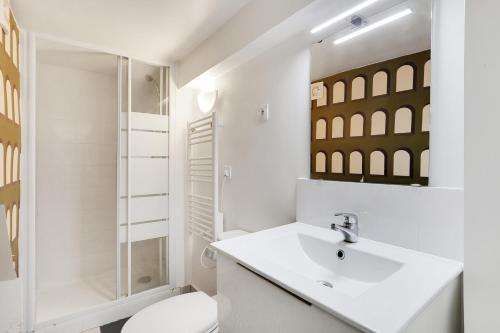 une salle de bain blanche avec des toilettes et un lavabo dans l'établissement Pick A Flat's Apartements in Louvre-Rivoli - Rue du Roule, à Paris