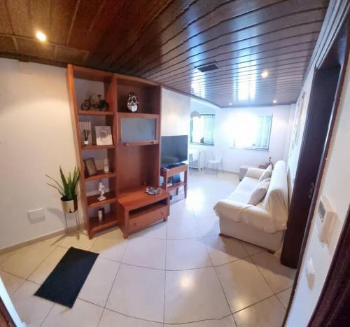 a living room with a white couch and a tv at T1 Monte Gordo, Urb. Monte Fino in Monte Gordo