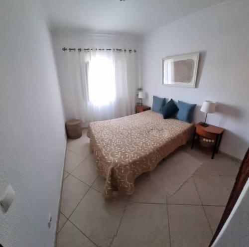 a bedroom with a bed and a window at T1 Monte Gordo, Urb. Monte Fino in Monte Gordo