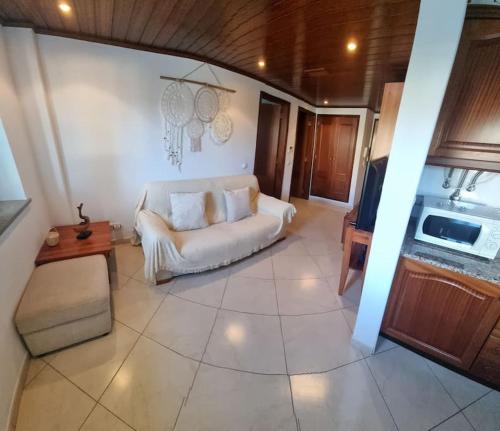 a living room with a white couch and a tv at T1 Monte Gordo, Urb. Monte Fino in Monte Gordo