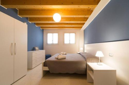 1 dormitorio con cama y pared azul en Ca' Martina, en Venecia